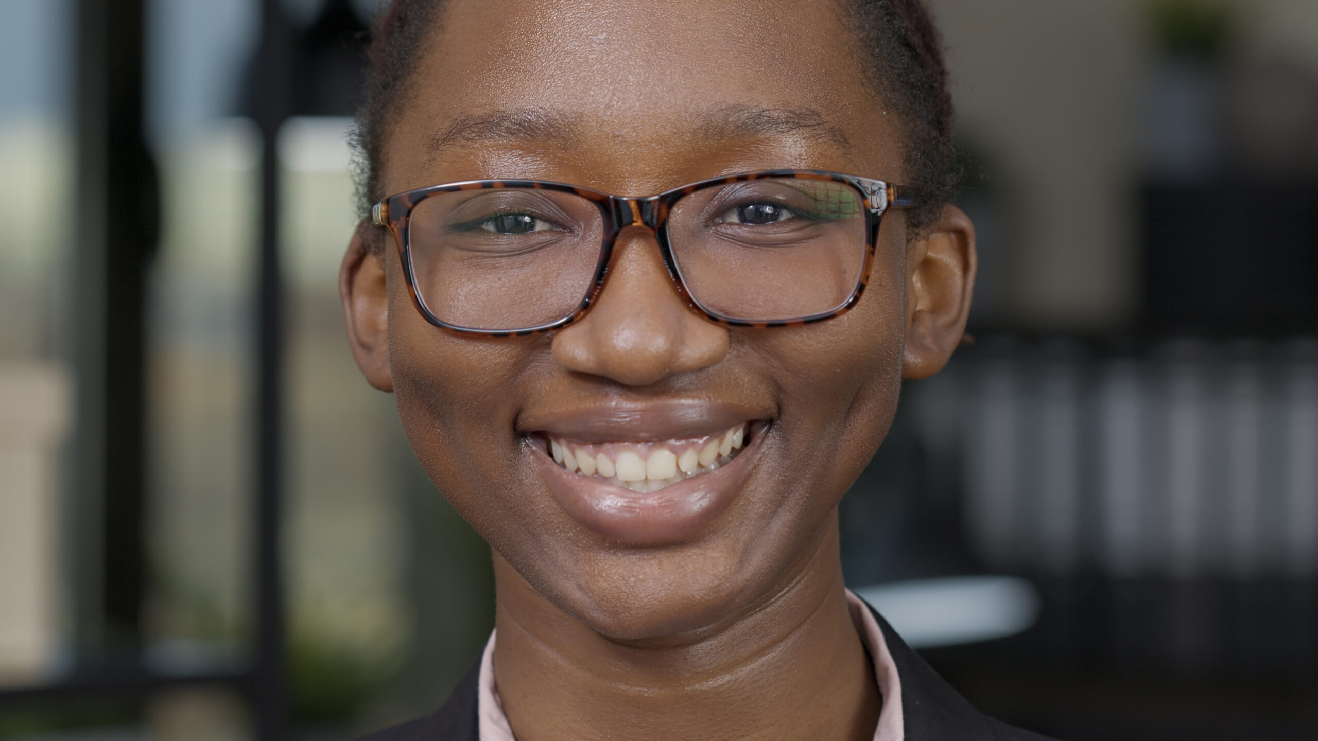 Portrait of female model smiling in front of camera, showing happy facial expressions. Young positive woman feeling cheerful and having natural skin, friendly beautiful person. Authentic feeling.
